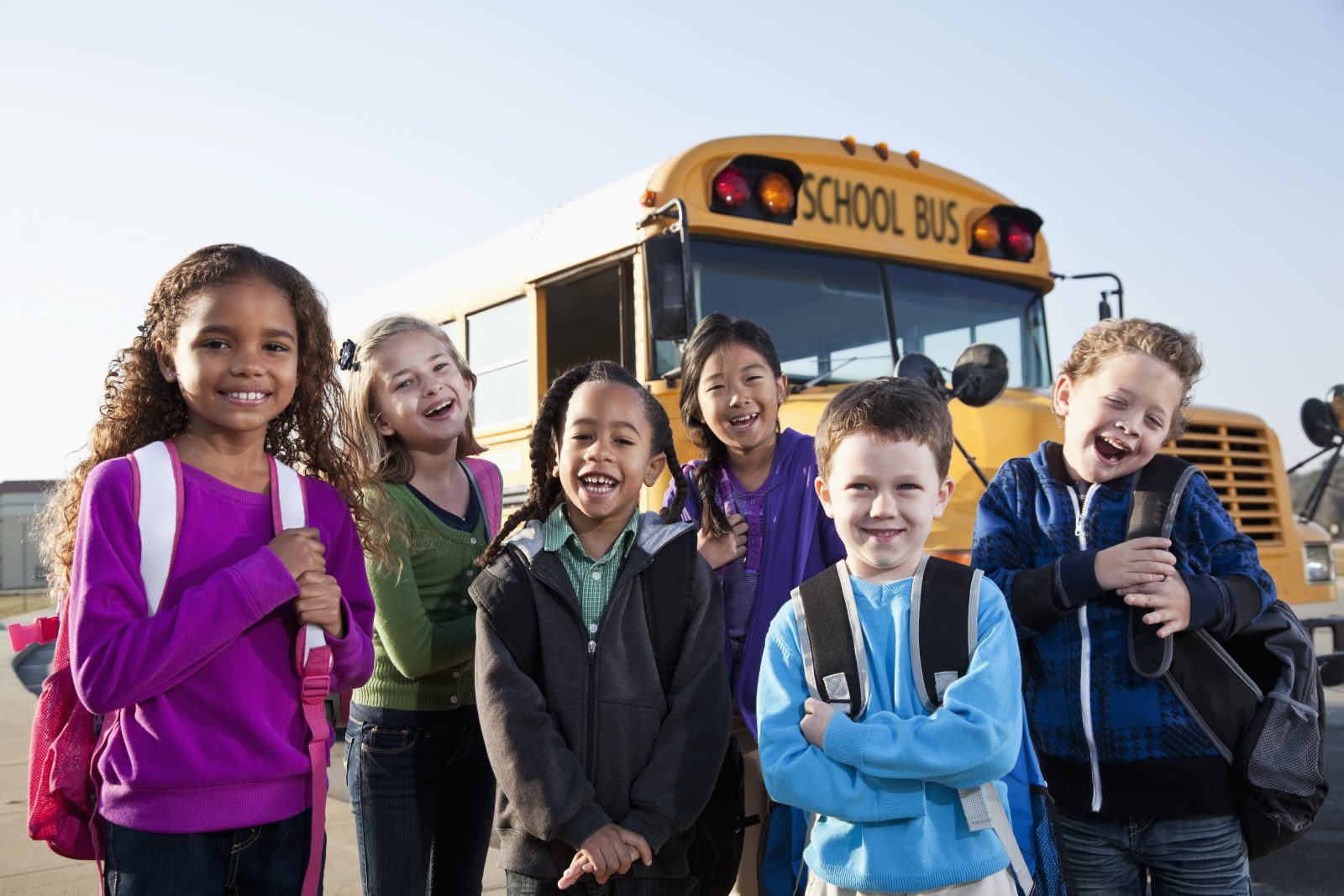Children-standing-outside-school-bus