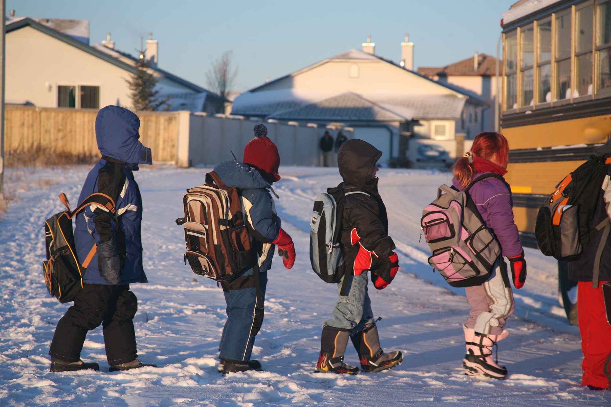 Cold children line up to board school bus in January.