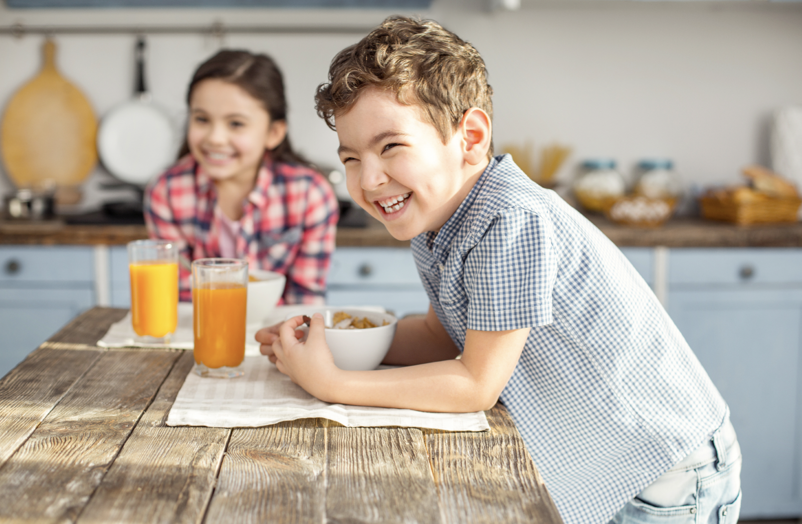 two kids smiling at breakfast while being secure